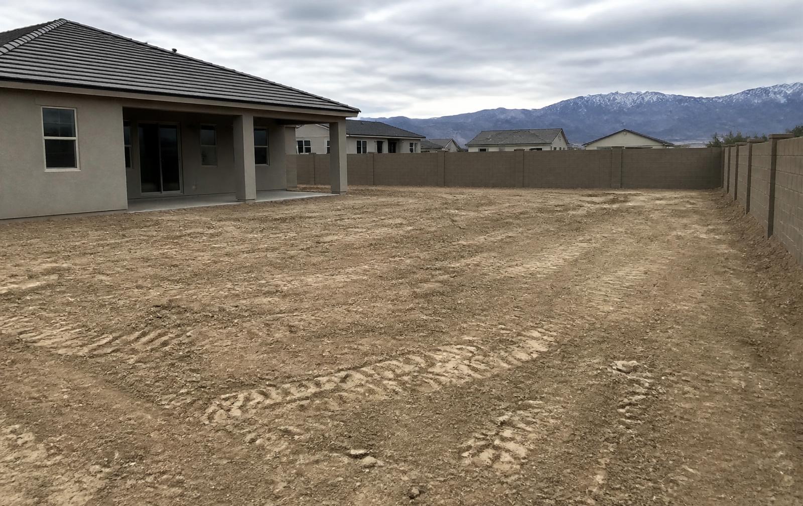 Bare dirt backyard before landscaping