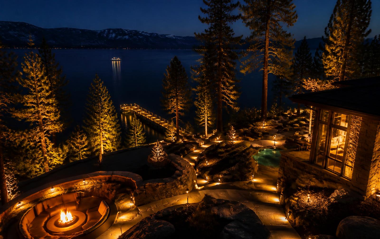 Lake Tahoe estate landscape lit with warm uplighting at night